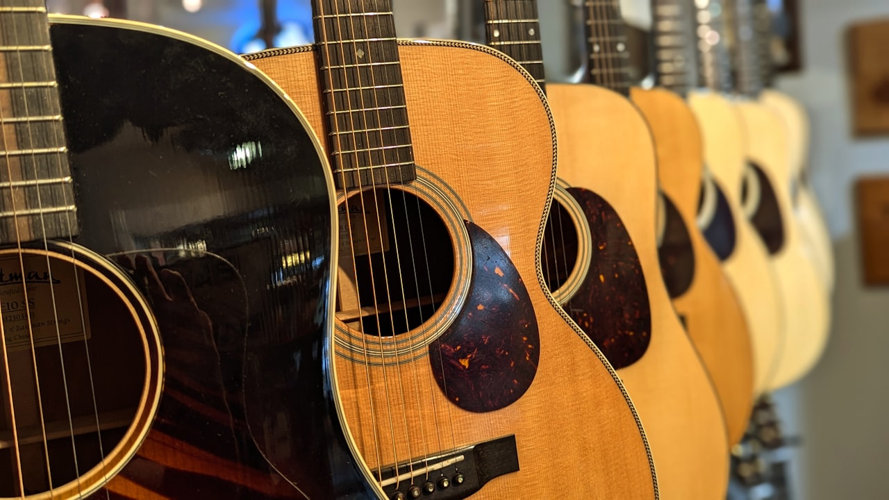 Pared de guitarras acústicas colgadas en el interior de una tienda de música